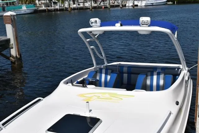 Slide: The Image of 2007 Glasstream 273 XS boat docked, featuring blue-striped seating and a sleek design. - 12