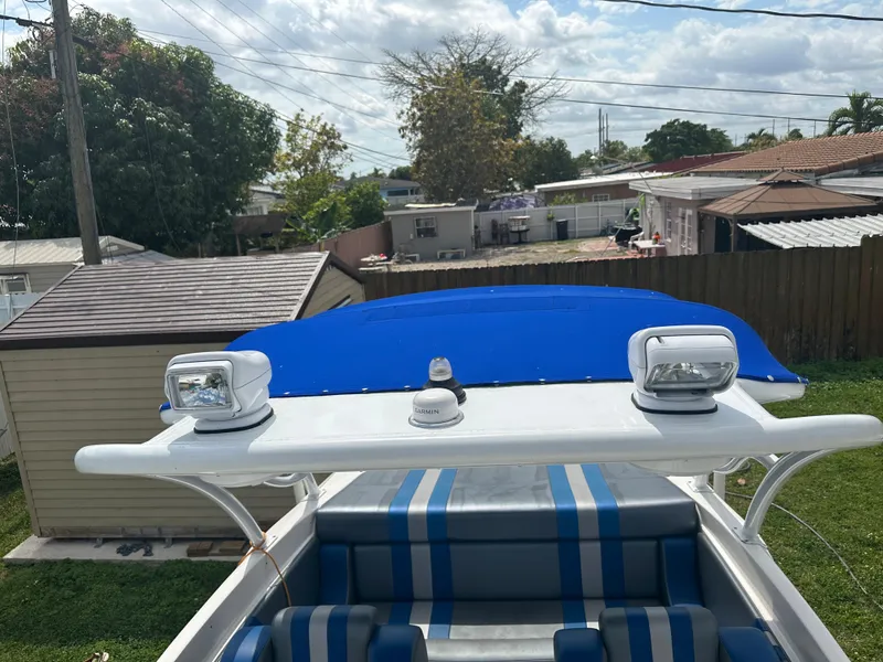 Slide: The Image of 2007 Glasstream 273 XS boat with blue canopy and striped seating in a residential area. - 24