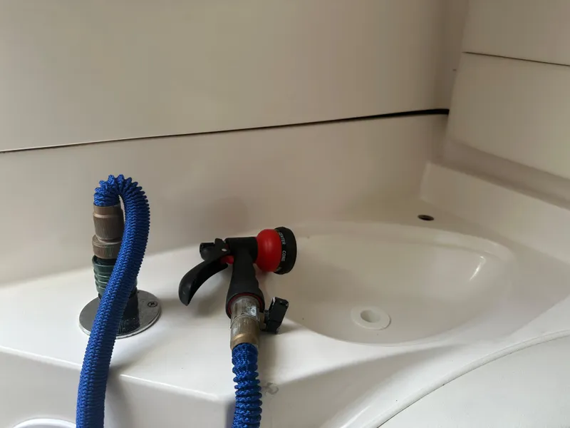 Slide: The Image of Boat sink area with blue hose and spray nozzle, Glasstream 273 XS, 2007 model. - 25