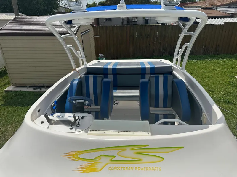 Slide: The Image of 2007 Glasstream 273 XS powerboat with blue-striped seating and logo, parked outdoors. - 34