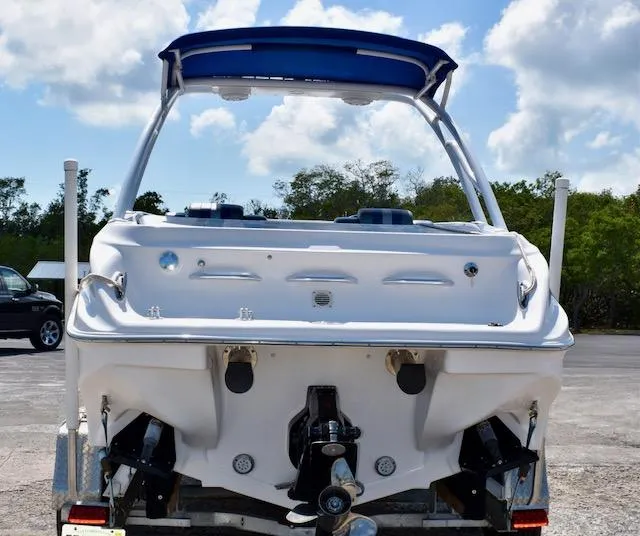 Slide: The Image of 2007 Glasstream 273 XS boat, rear view, with blue canopy, parked outdoors. - 4