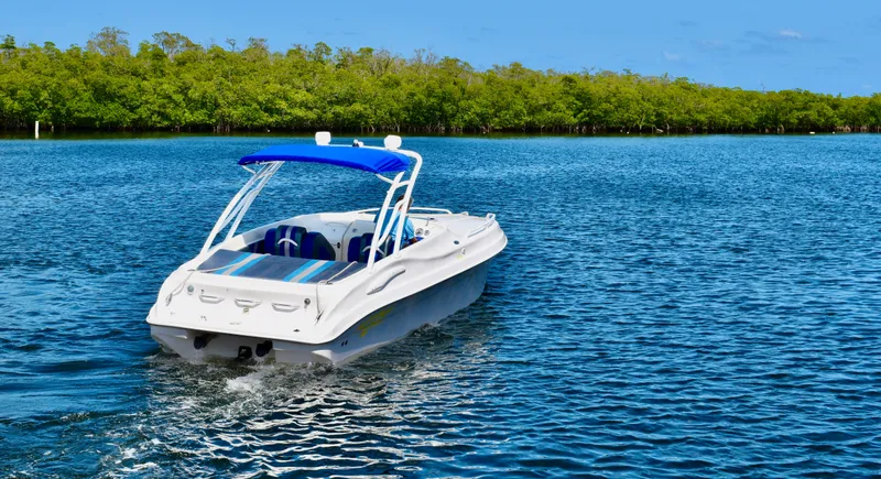 Slide: The Image of 2007 Glasstream 273 XS boat cruising on a serene lake with lush green shoreline. - 40
