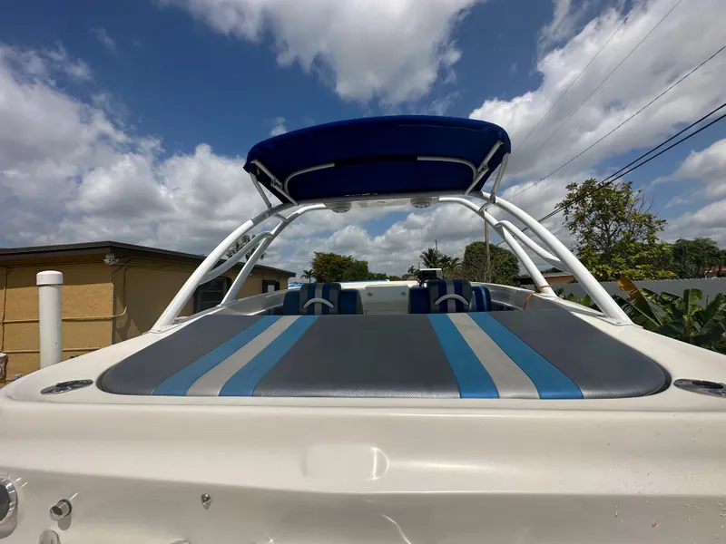 Slide: The Image of 2007 Glasstream 273 XS boat with blue canopy and striped seating under a cloudy sky. - 8