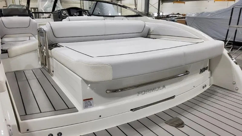 Slide: The Image of 2023 Formula 240 Bowrider boat with spacious seating and sleek design in a showroom. - 26