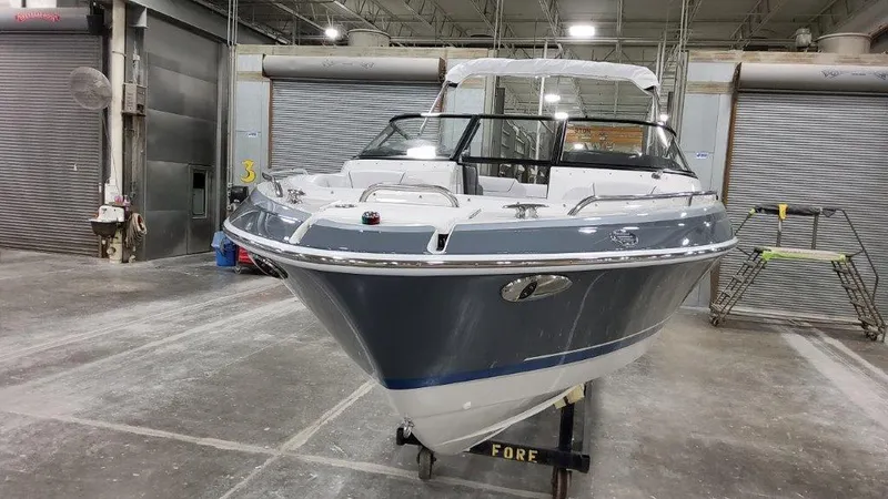 Slide: The Image of 2023 Formula 240 Bowrider interior with white seating and cup holders in a workshop. - 6