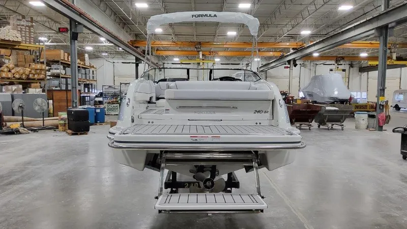 Slide: The Image of 2023 Formula 240 Bowrider interior with white seating and cup holders in a workshop setting. - 7