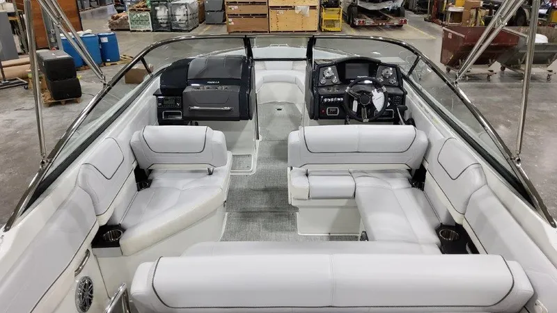 Slide: The Image of 2023 Formula 240 Bowrider interior with white seating in a spacious boat warehouse. - 8