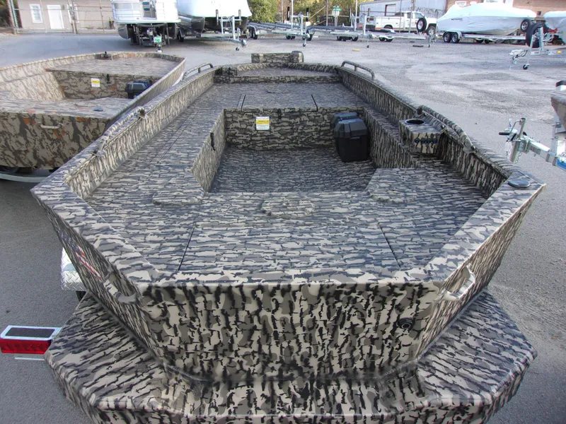 Slide: The Image of 2023 Legendcraft Ambush Elite 1652 MD boat with camouflage design, parked outdoors. - 3