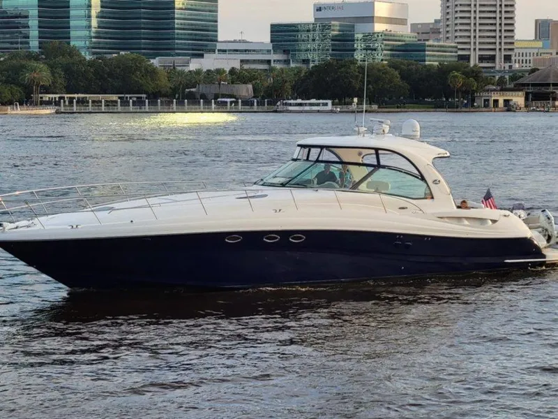The Image of 2005 Sea Ray 500 Sundancer yacht cruising on a river with cityscape background. - 0