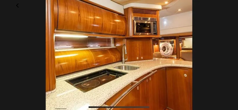 Slide: The Image of Luxurious kitchen interior of 2005 Sea Ray 500 Sundancer yacht with wooden cabinetry. - 6