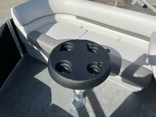 Slide: The Image of 2023 Sweetwater 2286SBX boat interior with seating and cup holder table. - 7