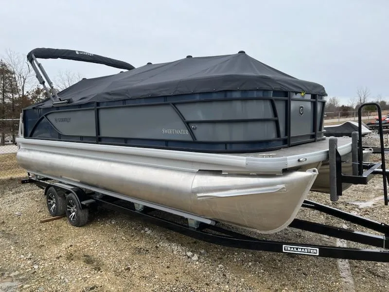 The Image of 2024 Sweetwater 2286SFL pontoon boat on a trailer, covered with a black tarp. - 0