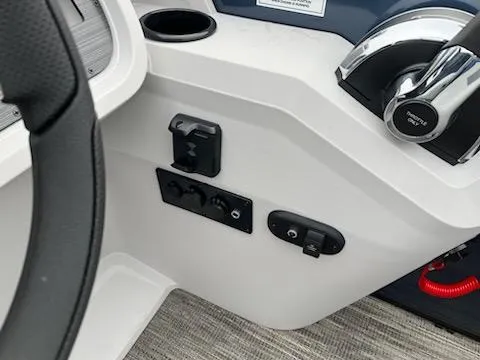 Slide: The Image of 2024 Sweetwater 2286SFL boat control panel with throttle, switches, and cup holder. - 6