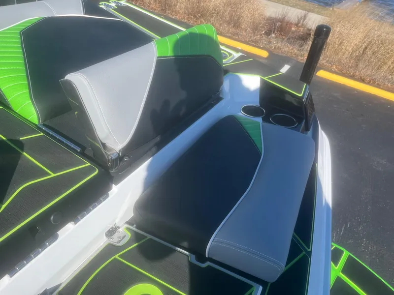 Slide: The Image of 2023 Centurion Fi23 boat interior with green and gray seating, cup holders, and sleek design. - 13