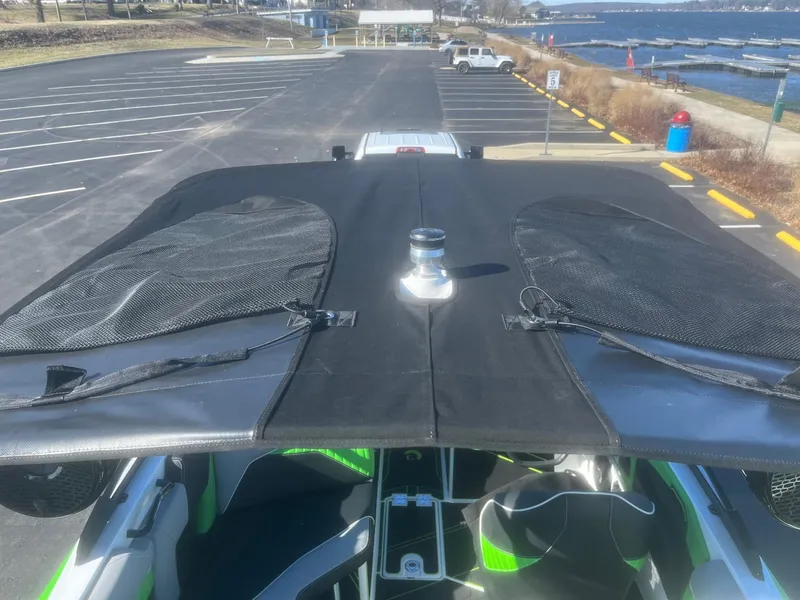 Slide: The Image of 2023 Centurion Fi23 boat with black canopy, parked near a waterfront. - 15