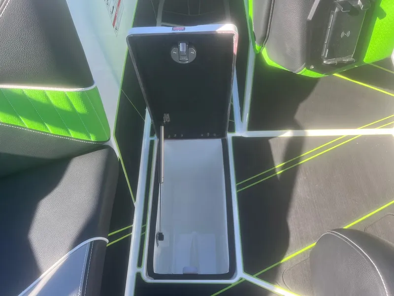 Slide: The Image of 2023 Centurion Fi23 boat interior with open storage compartment, featuring green and black seating. - 16