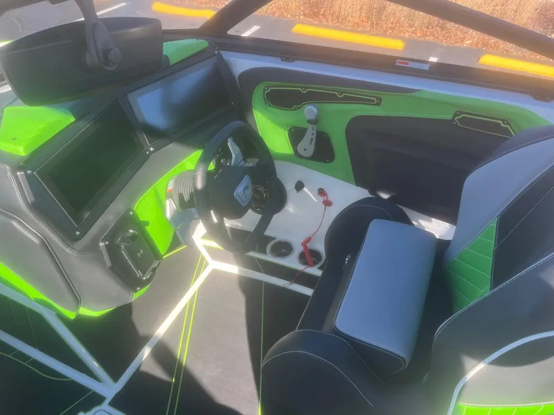 Slide: The Image of 2023 Centurion Fi23 boat interior with green accents and modern dashboard. - 9