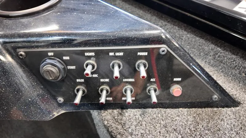 Slide: The Image of Control panel of a 2023 Lowe Stinger 198 boat with various switches. - 17