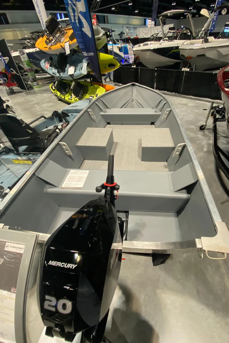 Slide: The Image of 2023 Starcraft Alaskan boat with Mercury 20 engine displayed at a boat show. - 3