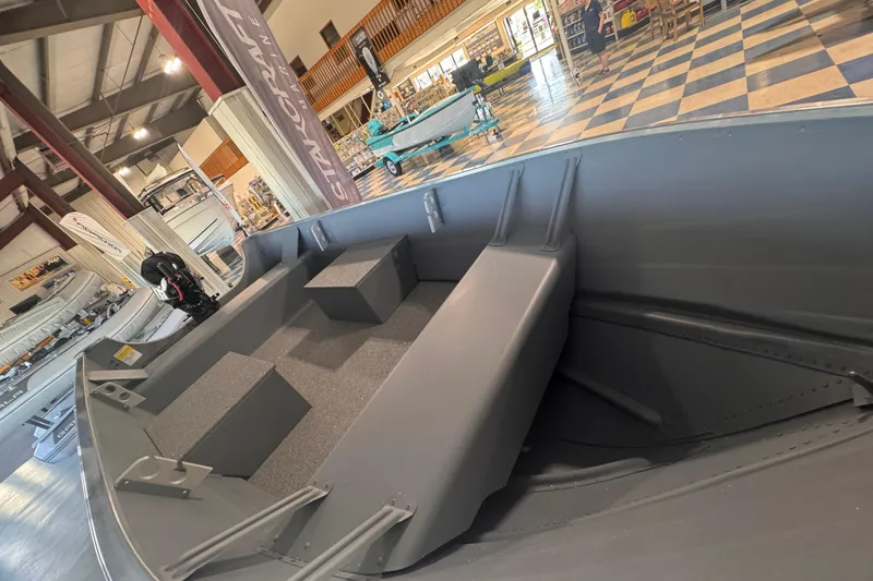 Slide: The Image of 2023 Starcraft Alaskan 12 boat interior in showroom with checkered floor. - 9