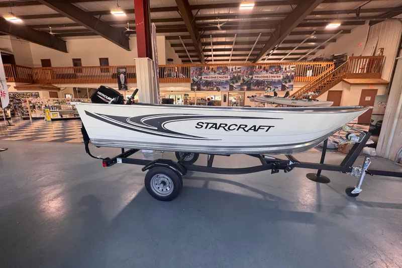 Slide: The Image of 2023 Starcraft Alaskan 12 boat displayed indoors on a trailer. - 1