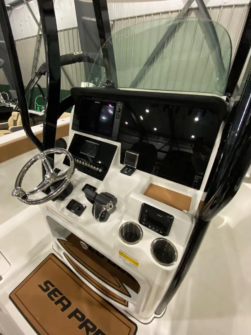 Slide: The Image of 2023 Sea Pro 259 DLX boat console with steering wheel and controls. - 10