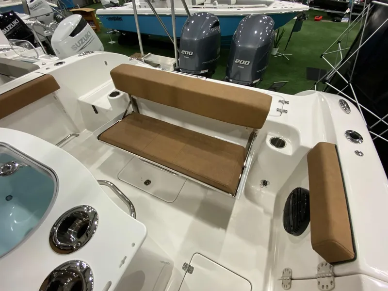 Slide: The Image of 2023 Sea Pro 259 DLX boat interior with tan seating and dual Suzuki engines. - 13