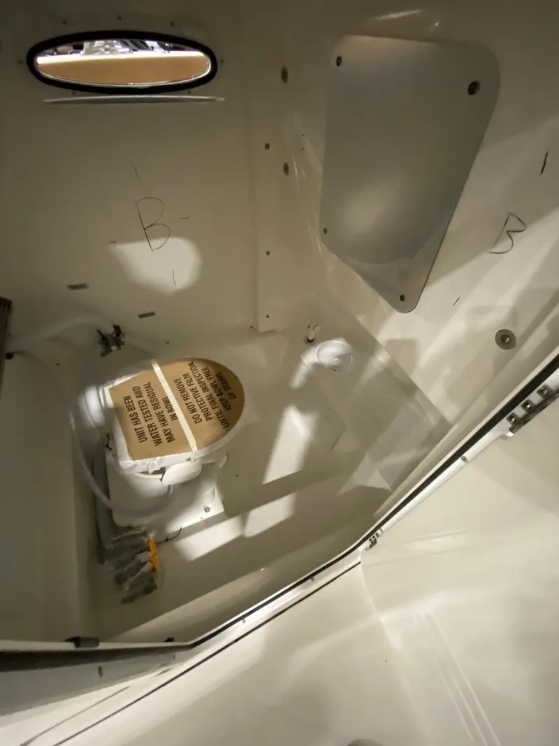 Slide: The Image of 2023 Sea Pro 259 DLX boat interior cabin with compact toilet. - 15