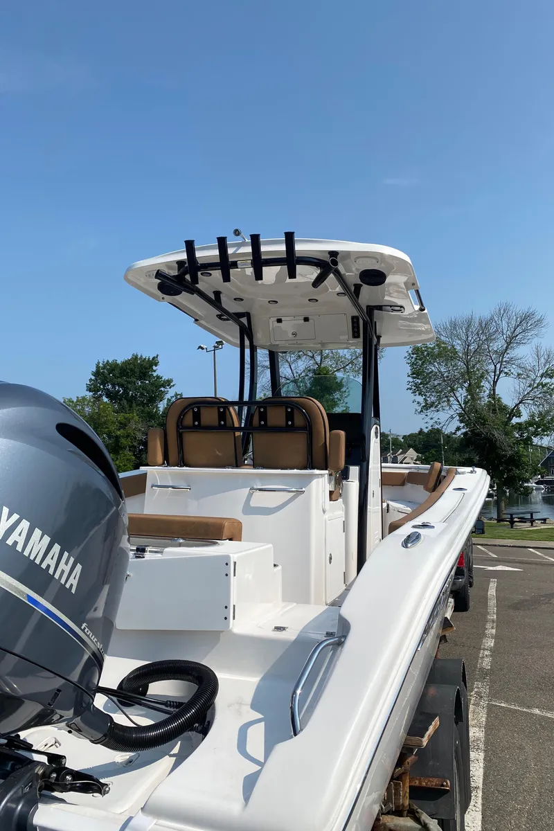 Slide: The Image of 2023 Sea Pro 259 DLX boat with Yamaha engine, docked on a sunny day. - 3