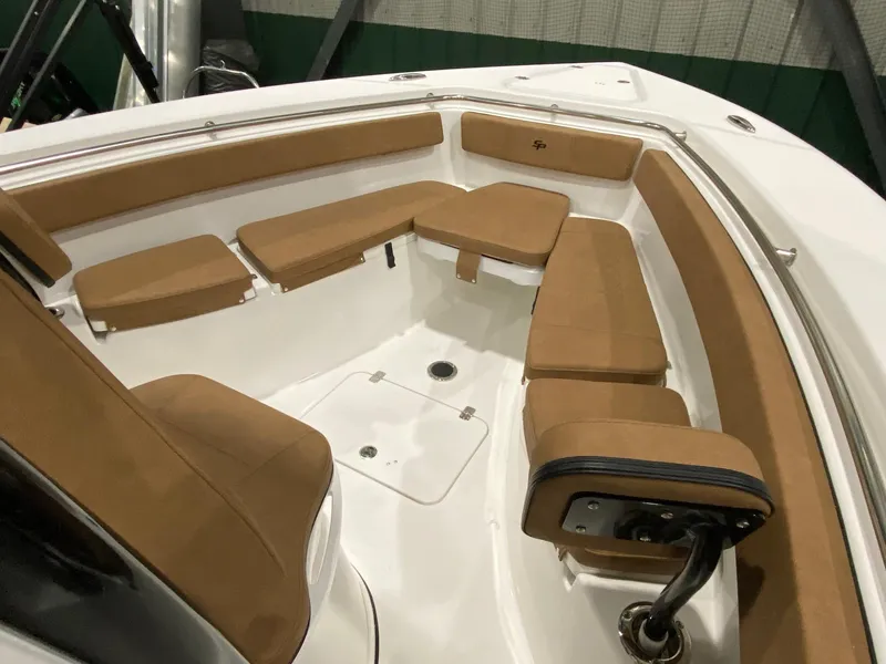 Slide: The Image of 2023 Sea Pro 259 DLX boat interior with tan seating and white deck. - 4