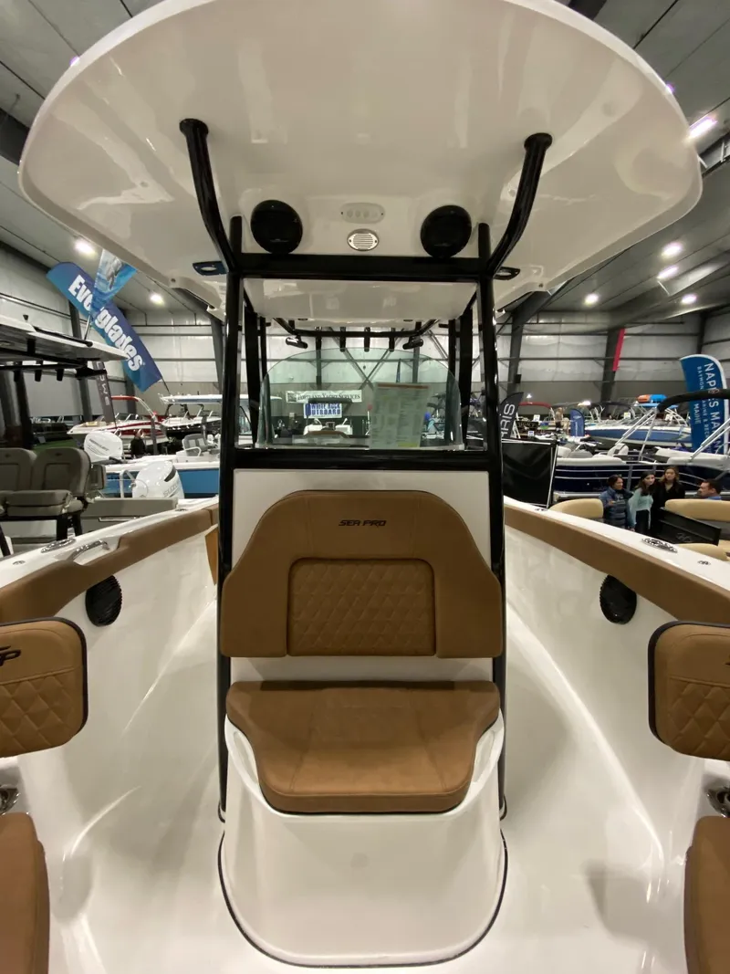 Slide: The Image of 2023 Sea Pro 259 DLX boat interior with tan seating and black T-top. - 6