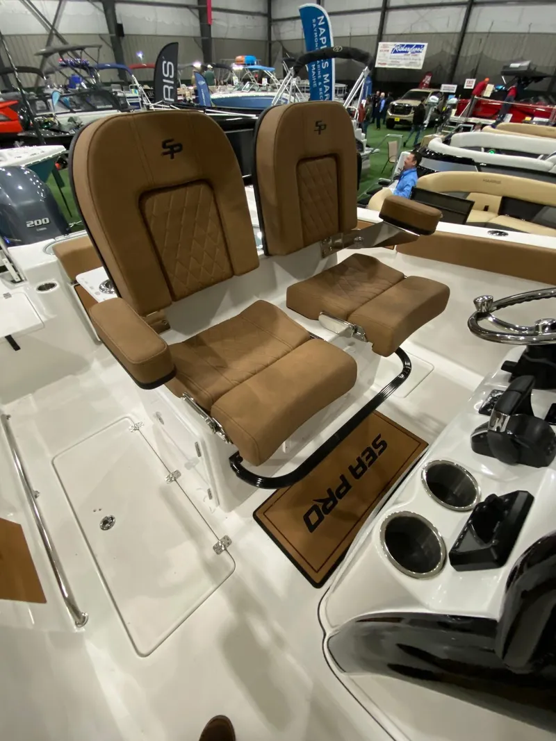 Slide: The Image of 2023 Sea Pro 259 DLX boat interior with tan seats and console. - 9