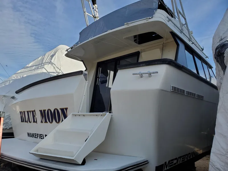 Slide: The Image of 1990 Mainship Mediterranean yacht "Blue Moon" docked, featuring sleek design and open rear deck. - 11