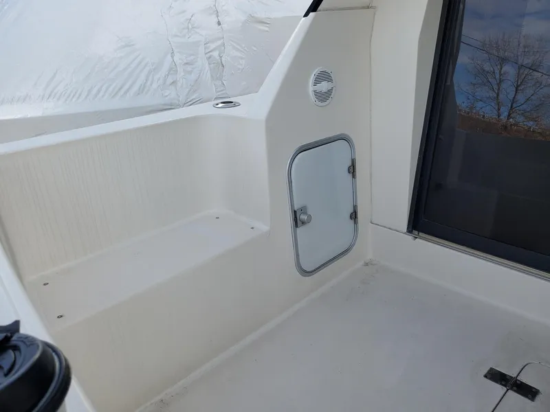 Slide: The Image of 1990 Mainship Mediterranean boat interior with white seating and storage compartment. - 12