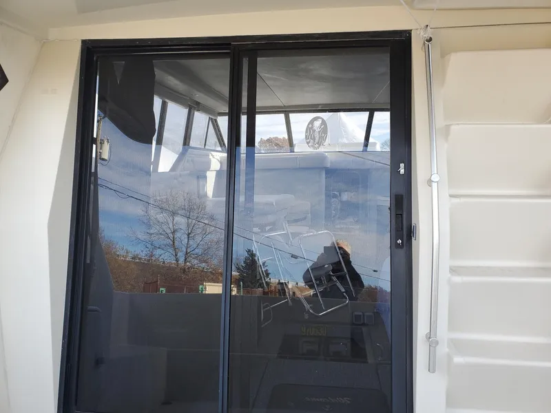 Slide: The Image of 1990 Mainship Mediterranean boat with glass sliding door and visible interior. - 13