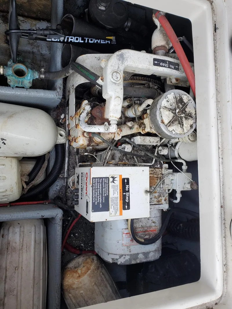 Slide: The Image of Engine compartment of a 1990 Mainship Mediterranean boat, showing mechanical components and wiring. - 14