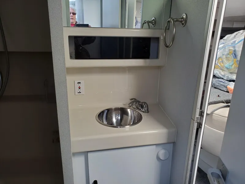 Slide: The Image of 1990 Mainship Mediterranean boat bathroom with sink, mirror, and storage cabinet. - 18