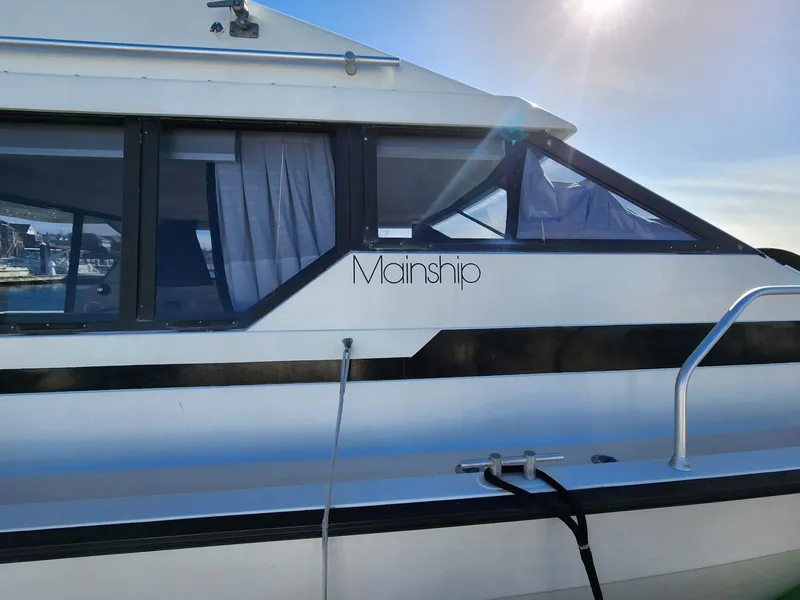 Slide: The Image of 1990 Mainship Mediterranean boat with sleek design and sunlit windows. - 2