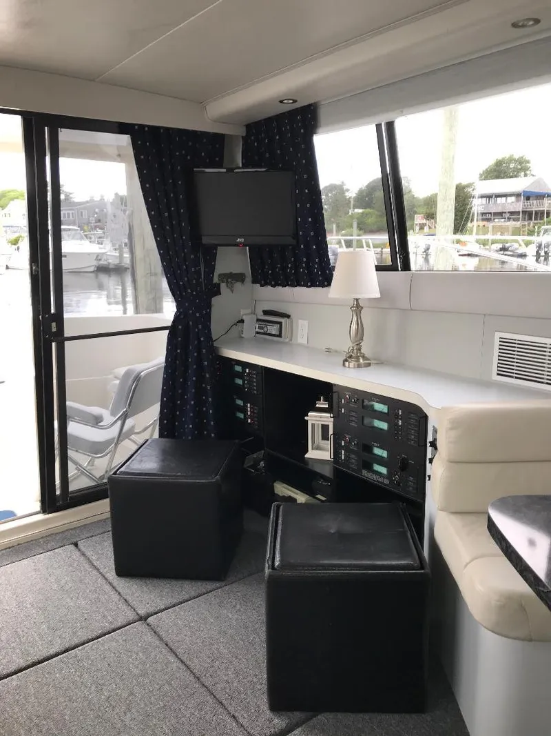 Slide: The Image of 1990 Mainship Mediterranean yacht interior with seating, control panel, and window view. - 24