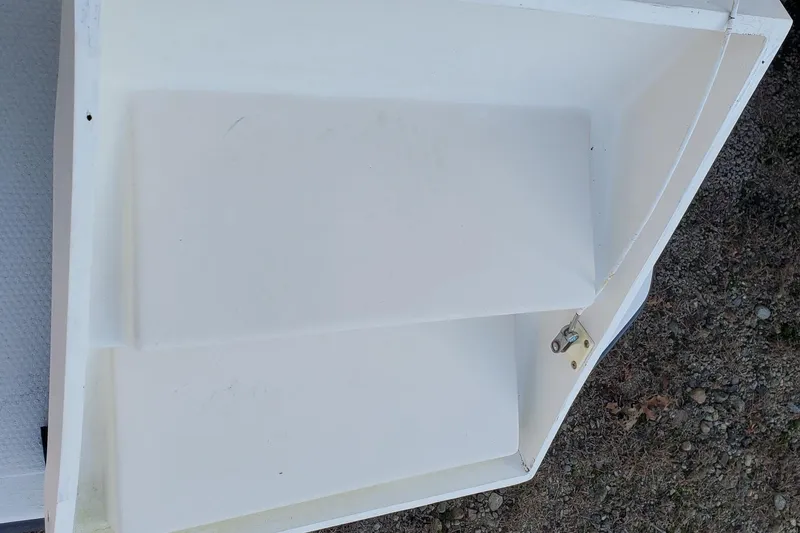 Slide: The Image of 1990 Mainship Mediterranean boat interior detail, white compartment with latch, on gravel surface. - 27