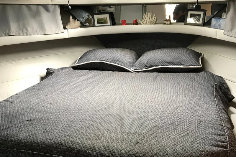 Slide: The Image of Cozy cabin bedroom in 1990 Mainship Mediterranean boat with gray bedding and decorative items. - 28