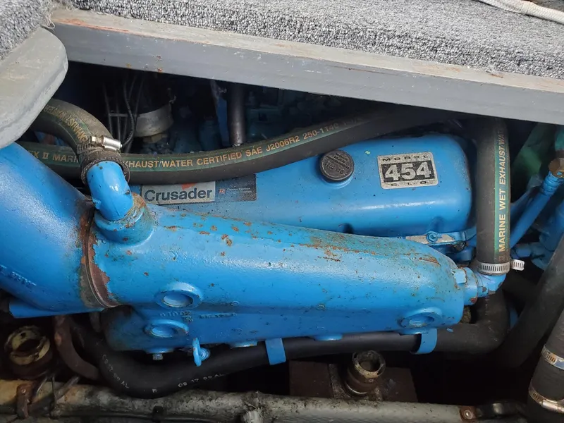 Slide: The Image of Engine of a 1990 Mainship Mediterranean boat, featuring a blue Crusader 454 motor. - 32