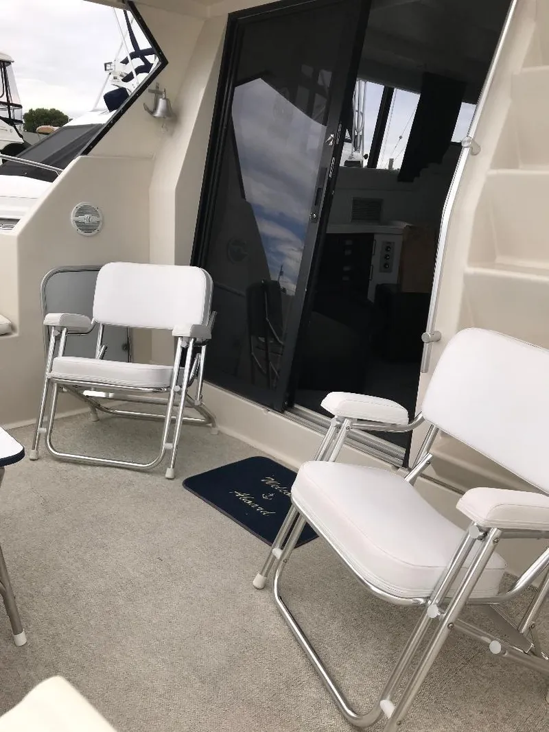 Slide: The Image of 1990 Mainship Mediterranean yacht interior with white chairs and sliding glass door. - 36