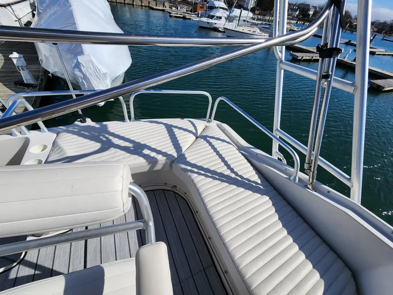 Slide: The Image of 1990 Mainship Mediterranean yacht deck with white seating and stainless steel railings. - 5
