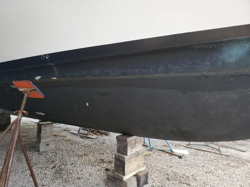 Slide: The Image of 1990 Mainship Mediterranean boat hull on blocks, side view. - 8