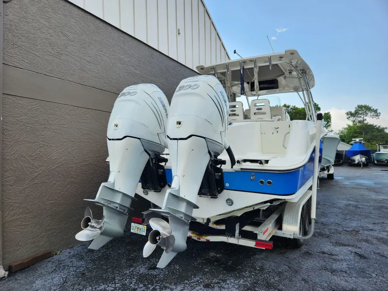 Slide: The Image of 2008 Boston Whaler 320 Outrage Cuddy Cabin with dual outboard engines, parked outdoors. - 1