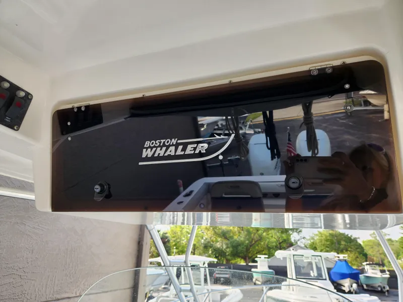 Slide: The Image of 2008 Boston Whaler 320 Outrage Cuddy Cabin dashboard with logo and marina view. - 12