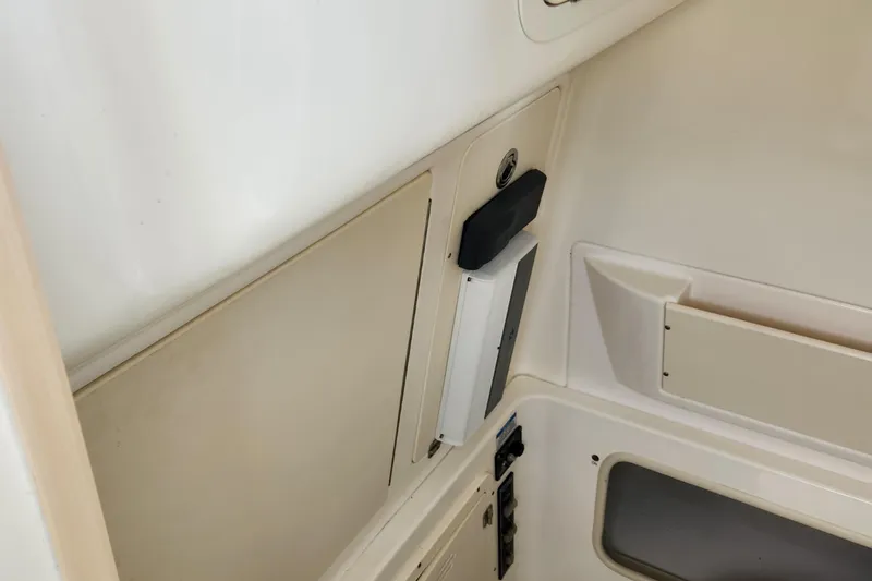 Slide: The Image of 2008 Boston Whaler 320 Outrage Cuddy Cabin interior detail, featuring storage compartments. - 16