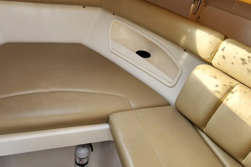 Slide: The Image of 2008 Boston Whaler 320 Outrage Cuddy Cabin interior with beige seating and storage. - 21