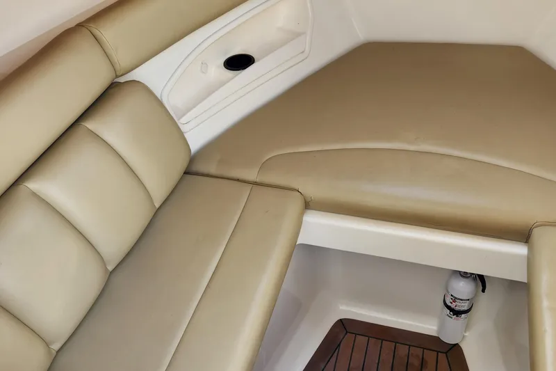 Slide: The Image of 2008 Boston Whaler 320 Outrage Cuddy Cabin interior with beige seating and wood flooring. - 22